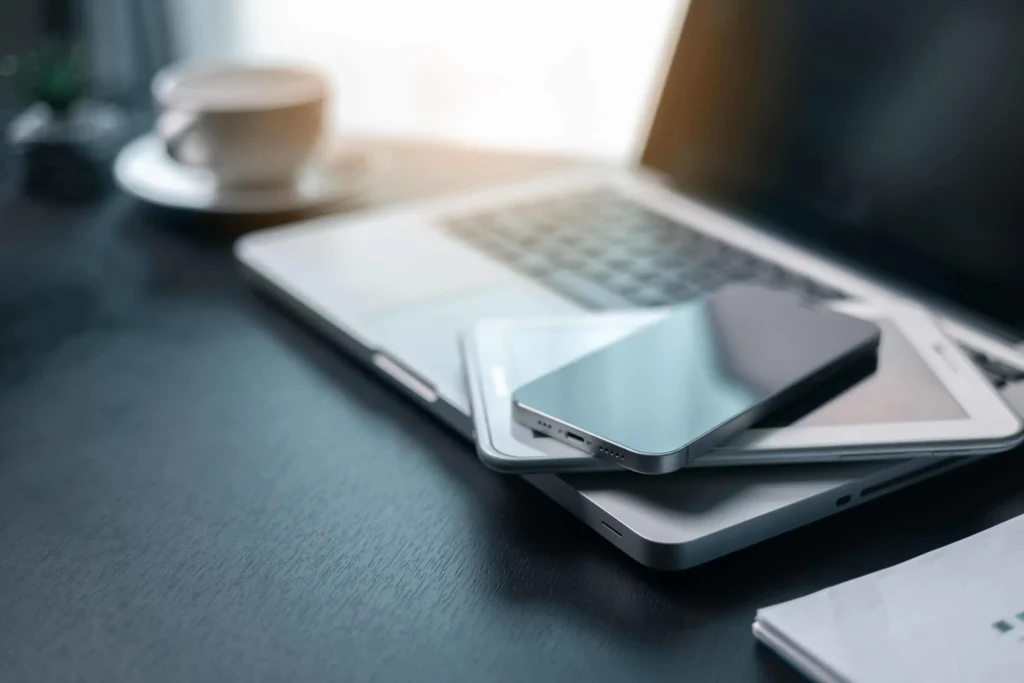 Laptop, tablet, and smartphone on a desk, representing managed IT services for multiple devices.