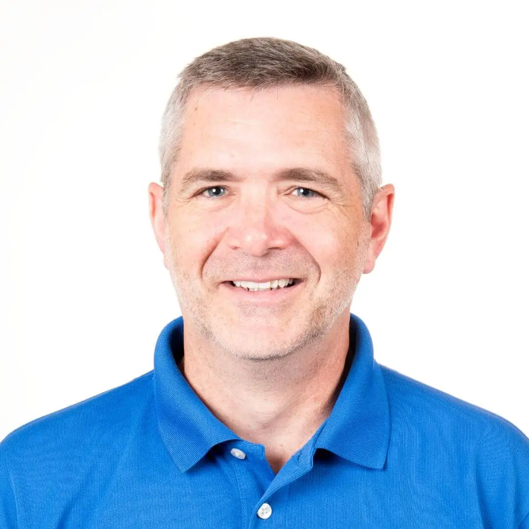 Member of our team smiling in blue, representing expertise in low voltage wiring services.