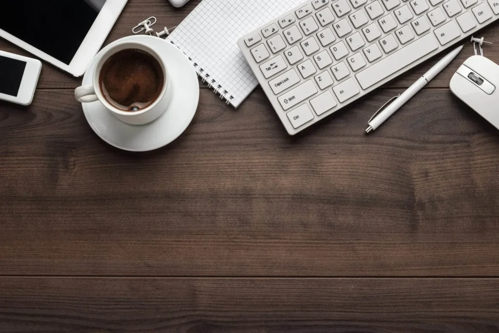 Managed Services, Desk with coffee, keyboard, mouse, tablet, and phone, representing IT consulting.