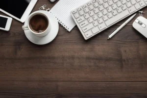 Managed Services, Desk with coffee, keyboard, mouse, tablet, and phone, representing IT consulting.
