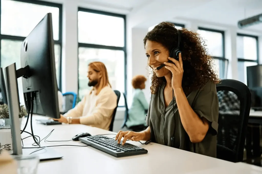 Smiling customer support agent with headset, representing business phone systems and VoIP solutions in Montgomery IL.