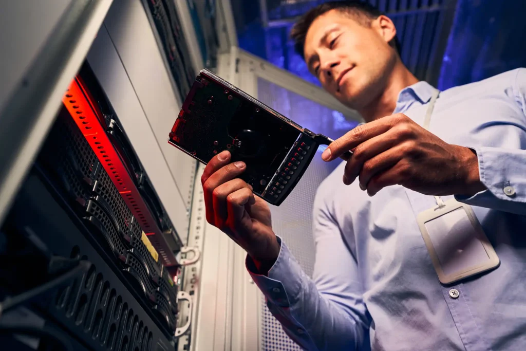 IT technician handling a server hard drive for data recovery and hardware support in Montgomery IL